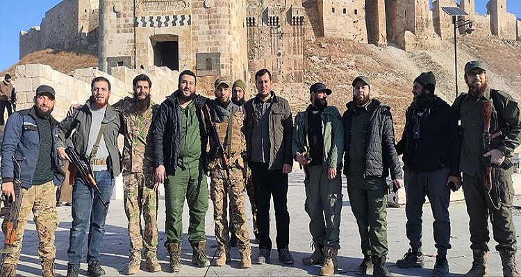 مقاتلو هيئة تحرير الشام أمام القلعة التي تم الاستيلاء عليها في حلب